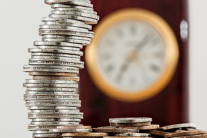 Stack of coins and clock background