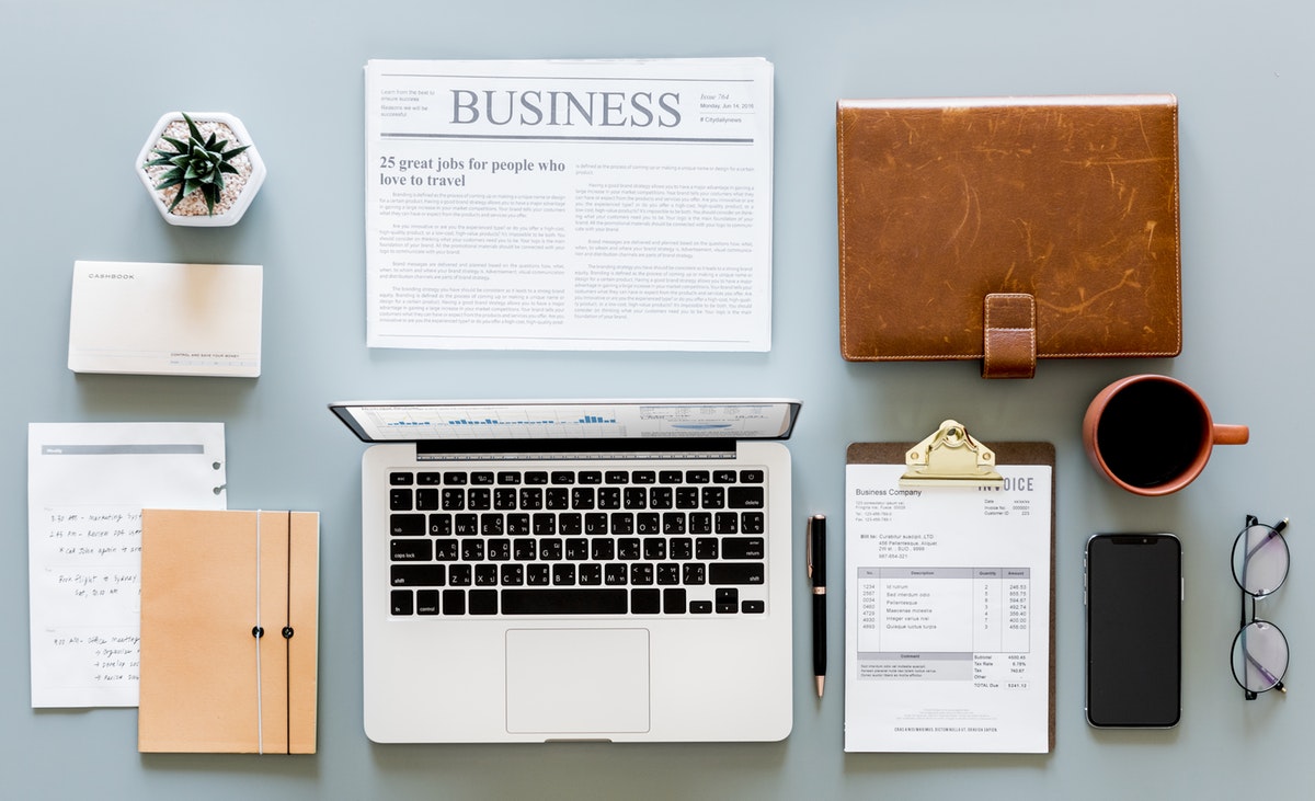 Desk flat lay with computer, business papers and other items