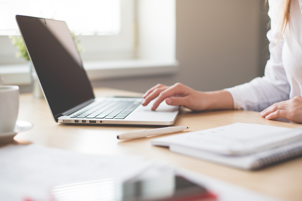 Desk with woman on her laptop computer